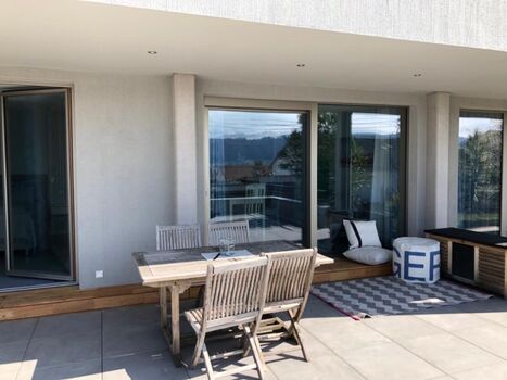 Esstisch und Sitzecke der teilüberdachten Terrasse