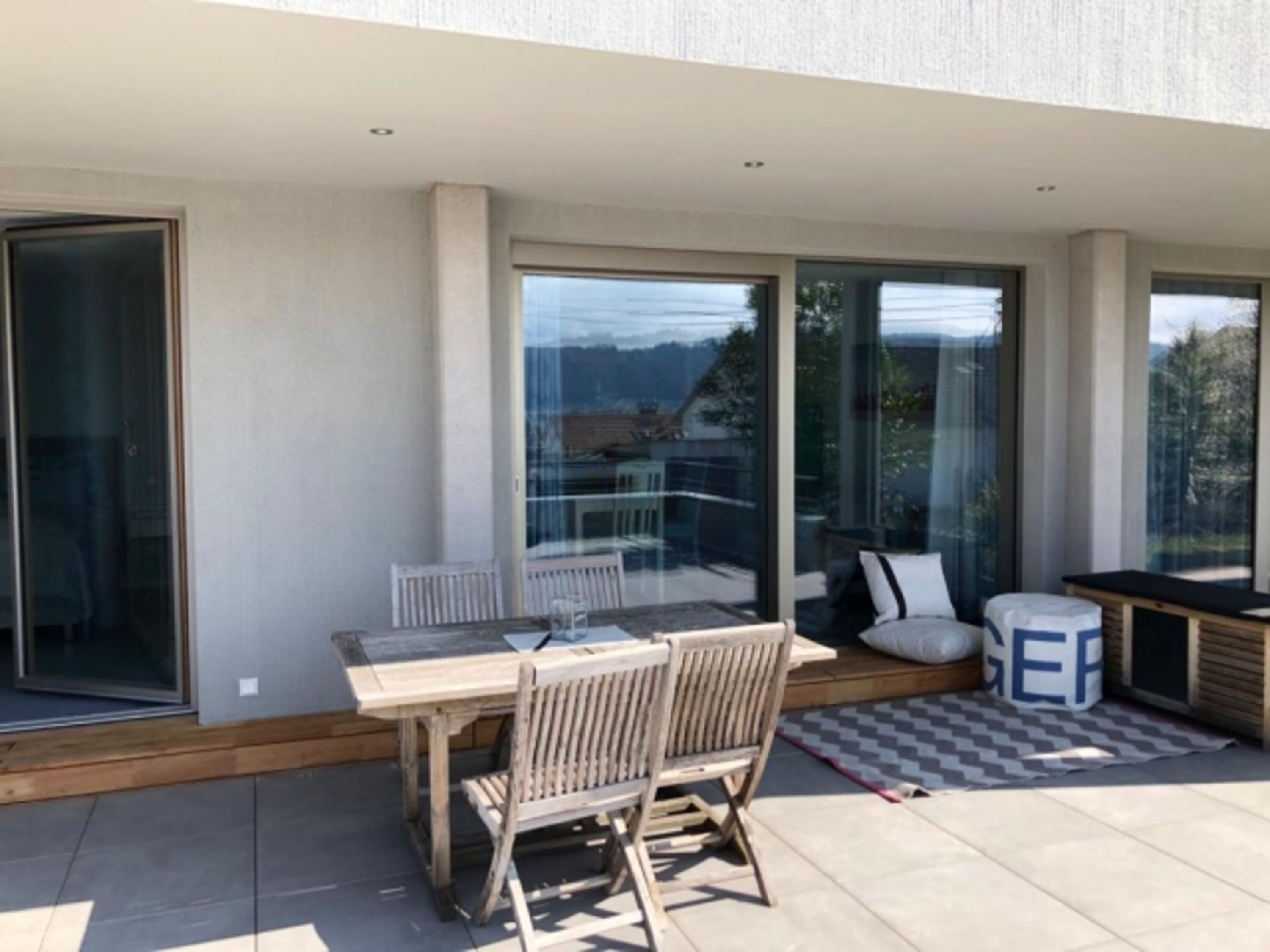 Esstisch und Sitzecke der teilüberdachten Terrasse