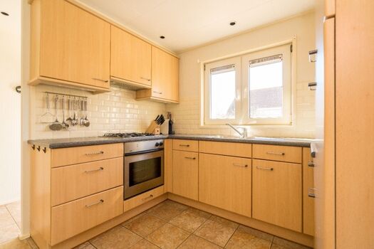 Küche mit Gasherd, Backofen und Kühlschrank