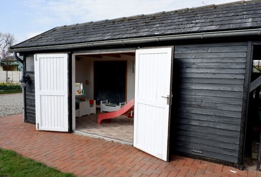 Spielhaus im Außenbereich mit Gartenzugang