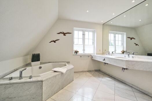 Badezimmer mit Doppelwaschbecken und Badewanne im Obergeschoss