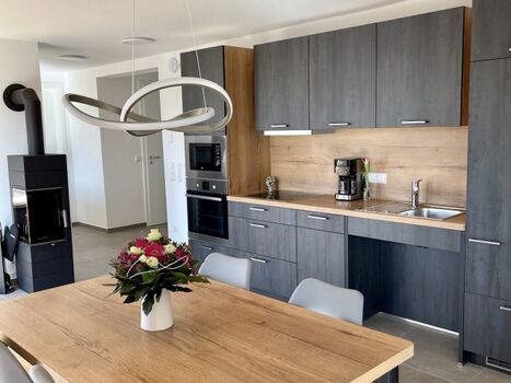 Die vollausgestattete Küche mit Essbereich und Schwedenofen