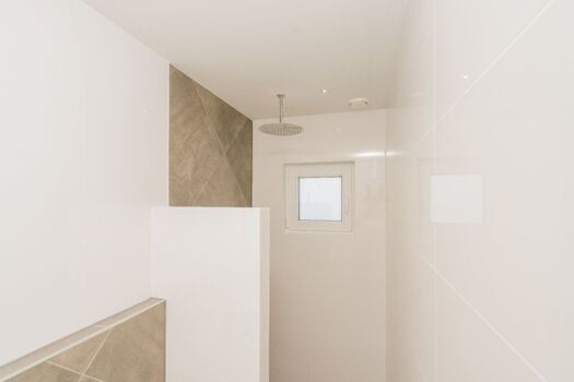 Badezimmer 1 mit Regendusche, Waschbecken und Toilette