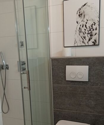 Badezimmer mit bodenebener Dusche, WC und Waschbecken