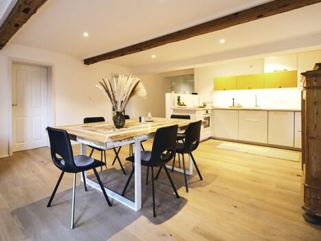 Massiver Bohlen-Esstisch neben der offenen Küche