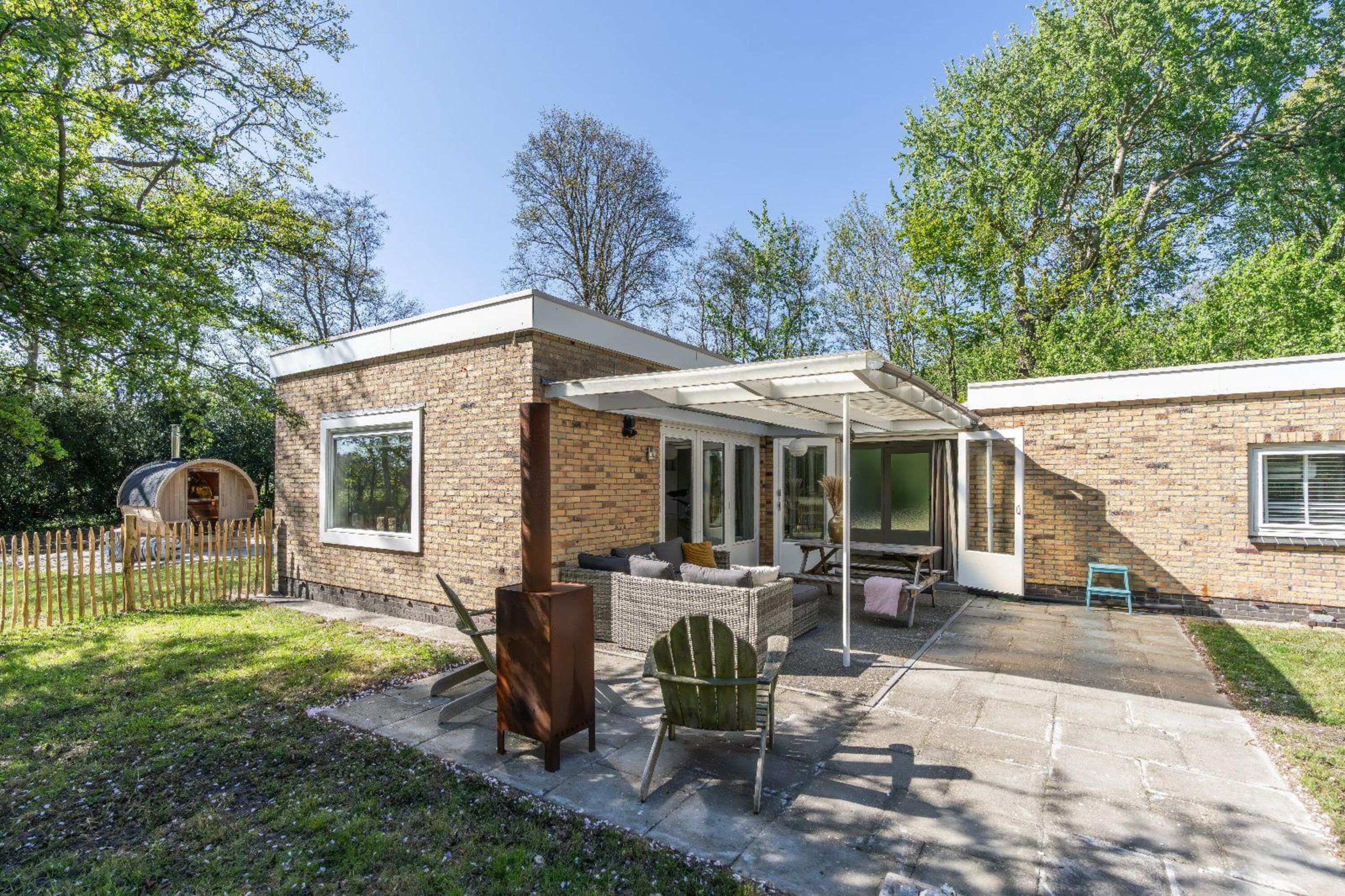 Die überdachte Terrasse mit Gartenmöbel und Außenkamin