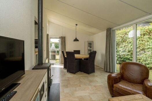 Das helle Wohnzimmer mit Sitzgruppe und Kaminofen