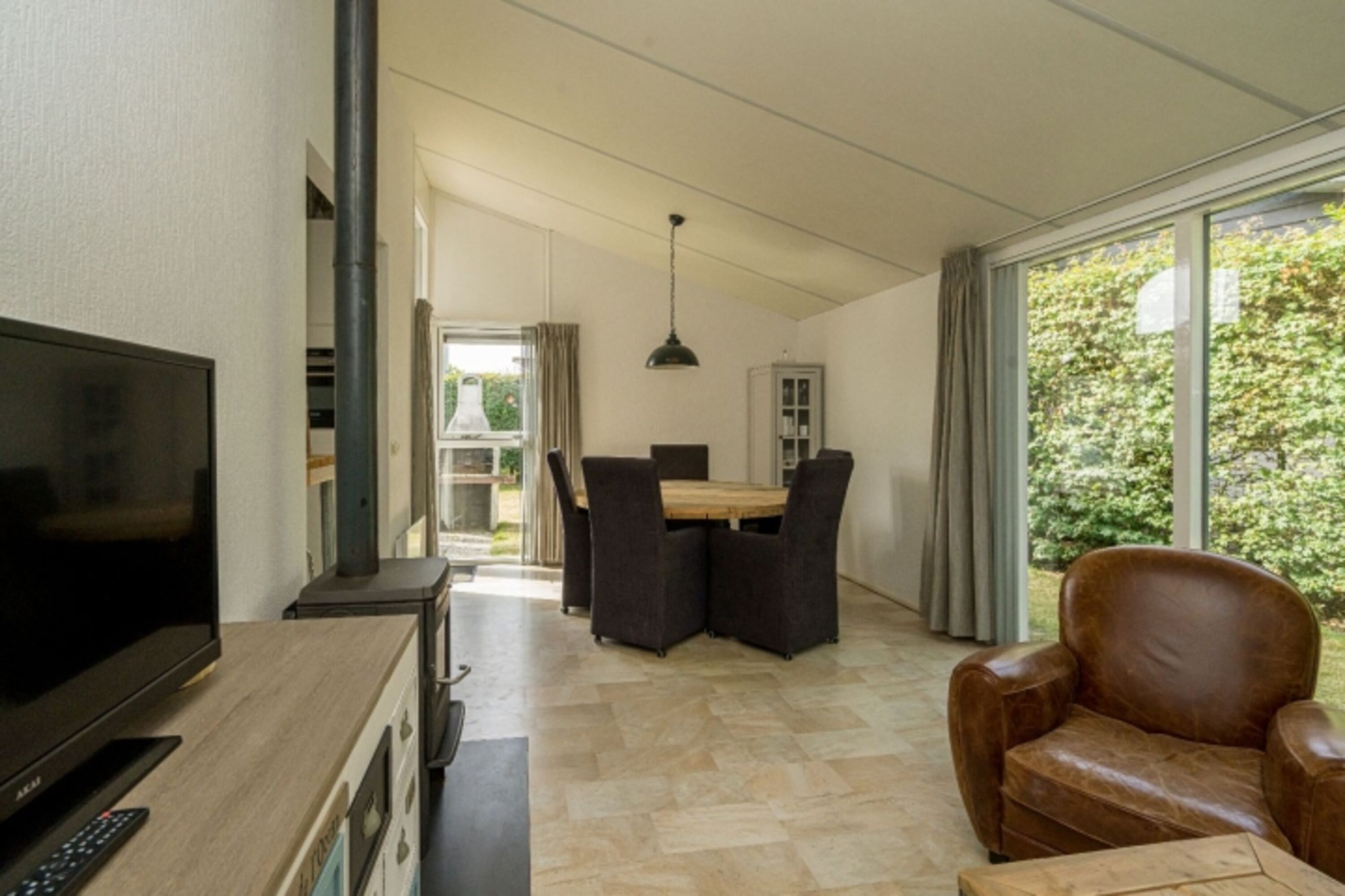 Das helle Wohnzimmer mit Sitzgruppe und Kaminofen