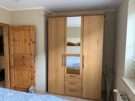 Der Kleiderschrank im Schlafzimmer bietet genug Stauraum