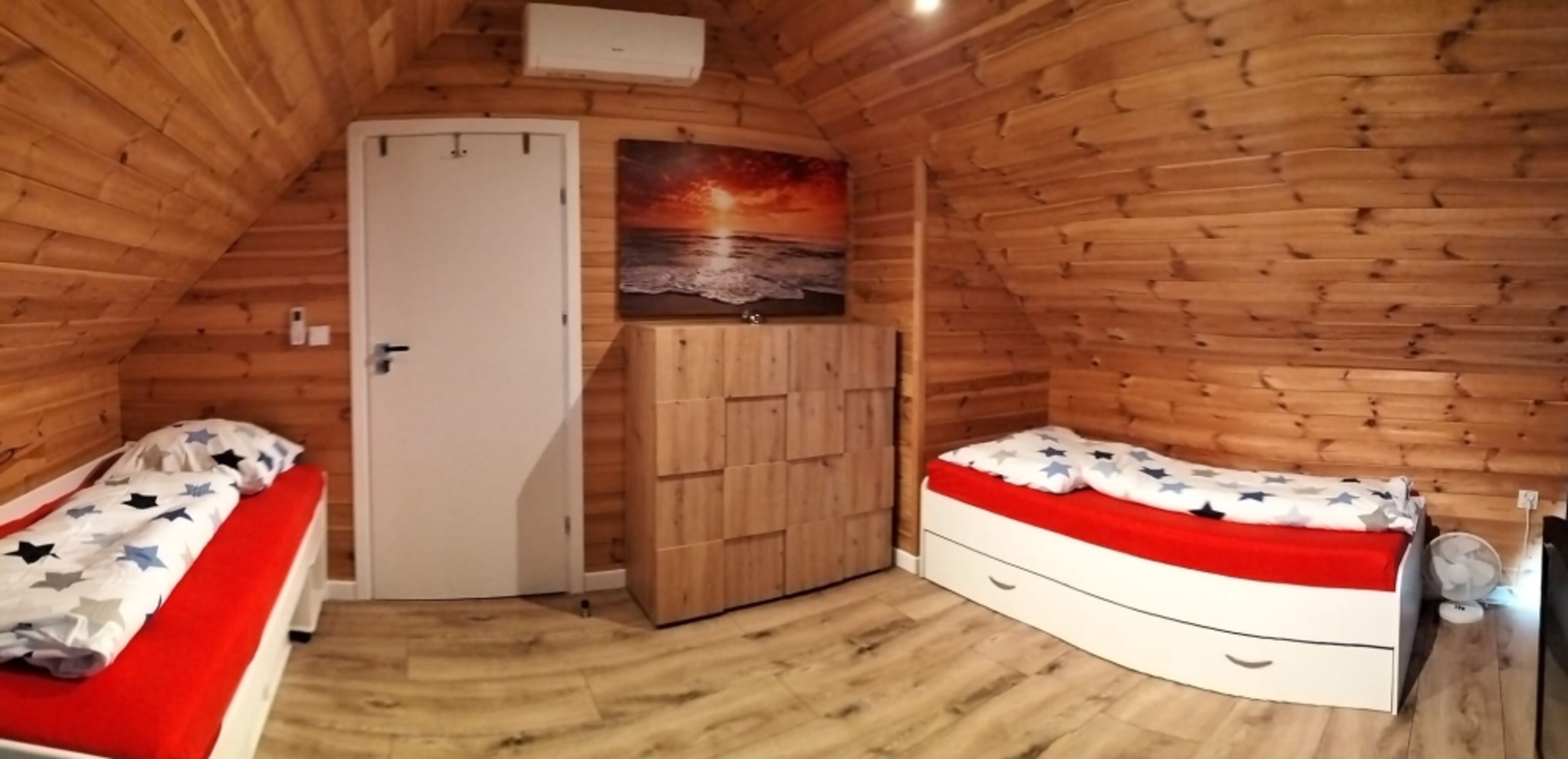 Schlafzimmer 2 im Obergeschoss mit drei Einzelbetten, geräumiger Kommode, Klimaanlage und TV.