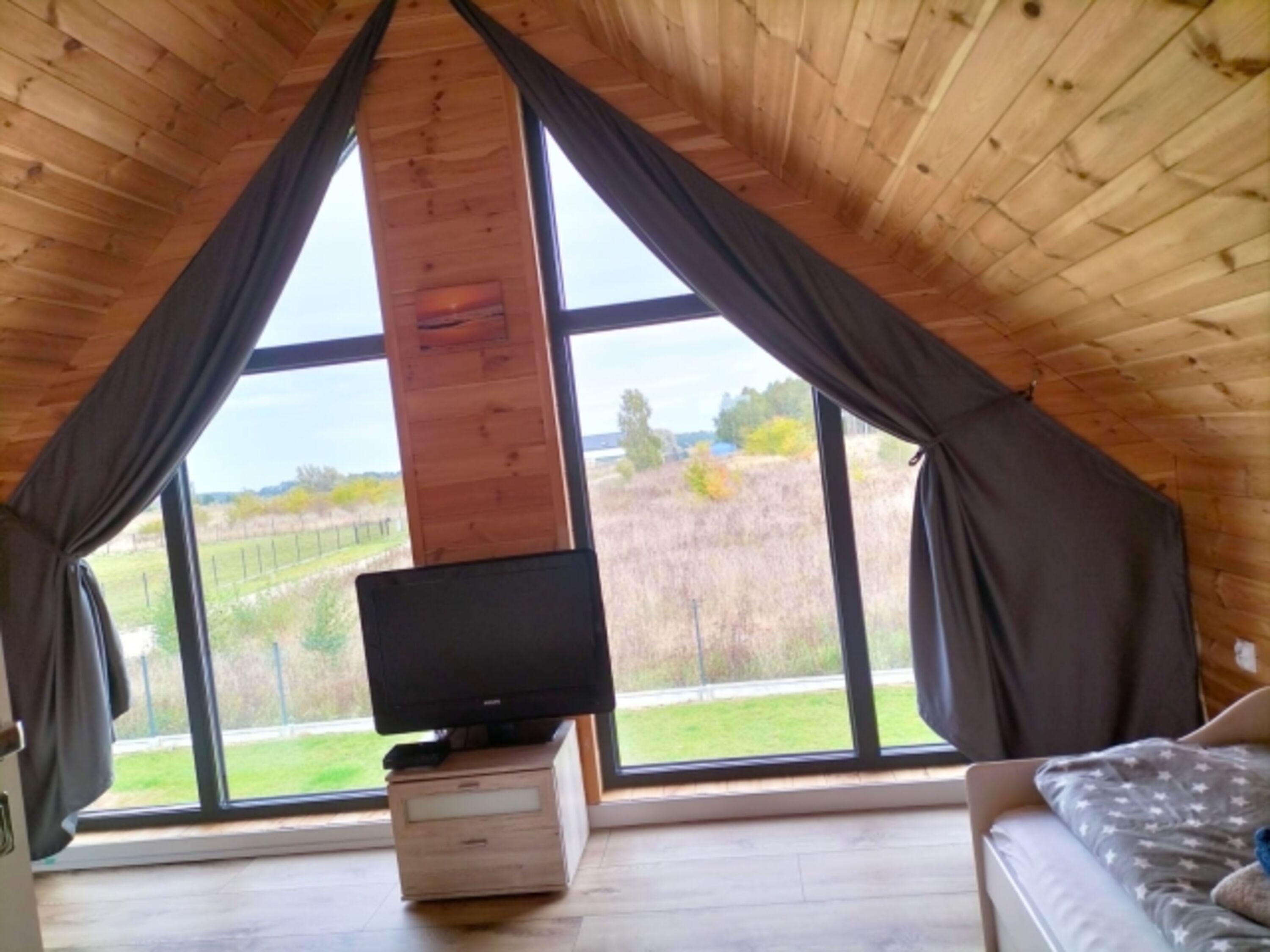 Aufwachen mit Ausblick: Traumhafte Panorama-Giebelfenster für viel Tageslicht und ein Fernseher für gemütliche Stunden im Bett.