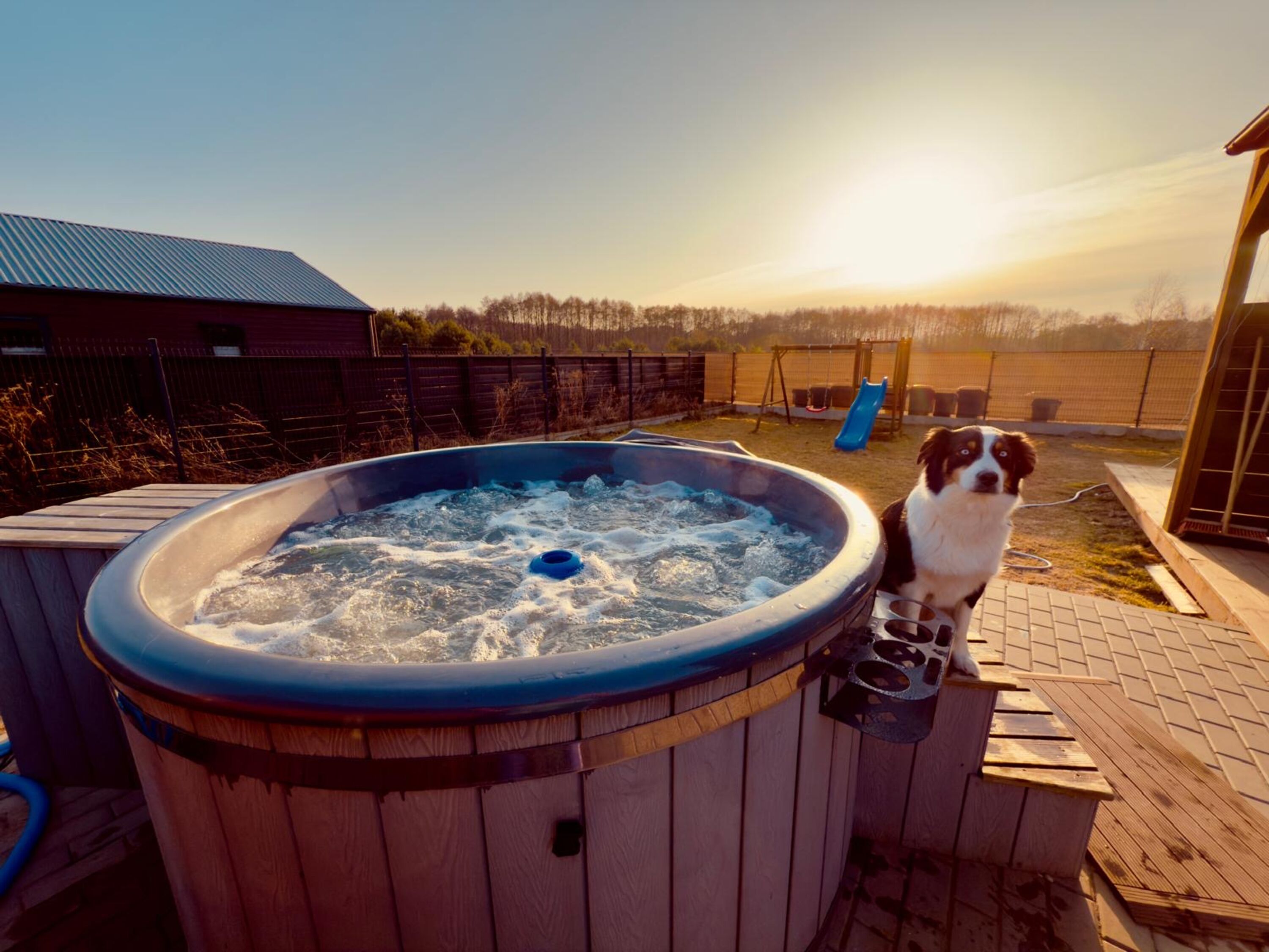 Wellness-Moment am späten Nachmittag: Im warmen Hot Tub entspannen, während dein Vierbeiner die Sonnenstrahlen auf der Terrasse genießt.