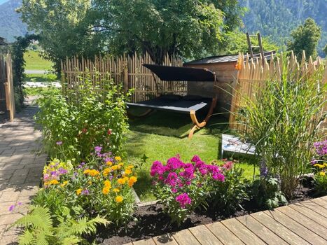 Eingezäunter Garten mit überdachter Holzterrasse und exklusiver Doppelliege