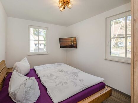 Schlafzimmer im EG mit Doppelbett und Fernseher