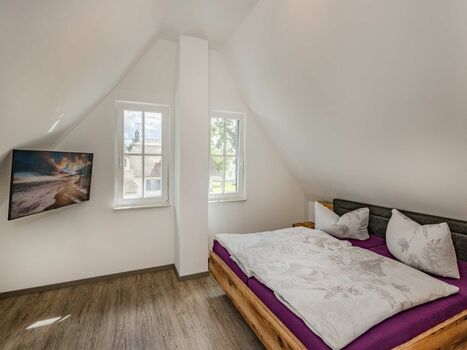 Schlafzimmer im OG mit Doppelbett, TV und Kleiderschrank