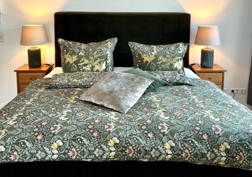 Zimmer mit Boxspringbett und Zugang zum Balkon