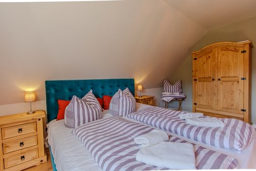 Schlafzimmer mit großem Doppelbett und Blick zum Hochwald