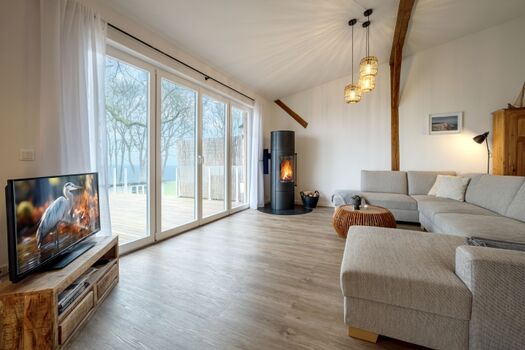 Wohnbereich mit großer Couch, Kamin und Meerblick