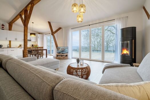 Wohnbereich mit großer Couch, Kamin und Meerblick