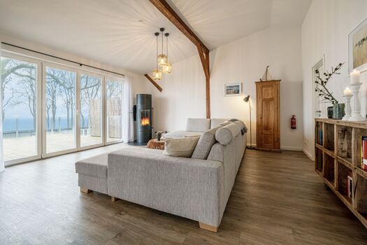 Wohnbereich mit großer Couch, Kamin und Meerblick