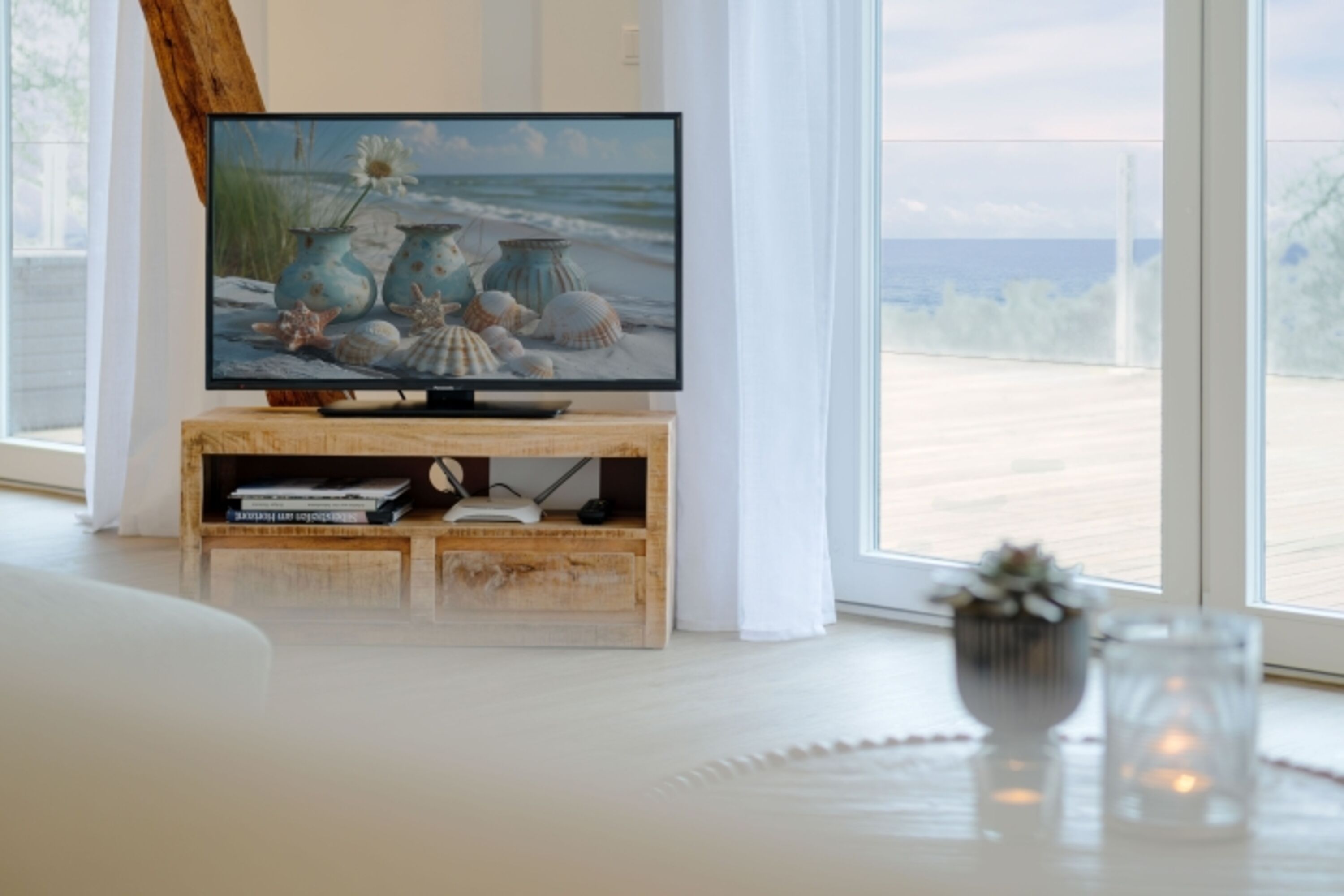 Wohnbereich mit großer Couch, Kamin und Meerblick