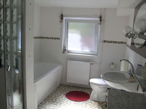 Das Badezimmer mit Badewanne und Dusche