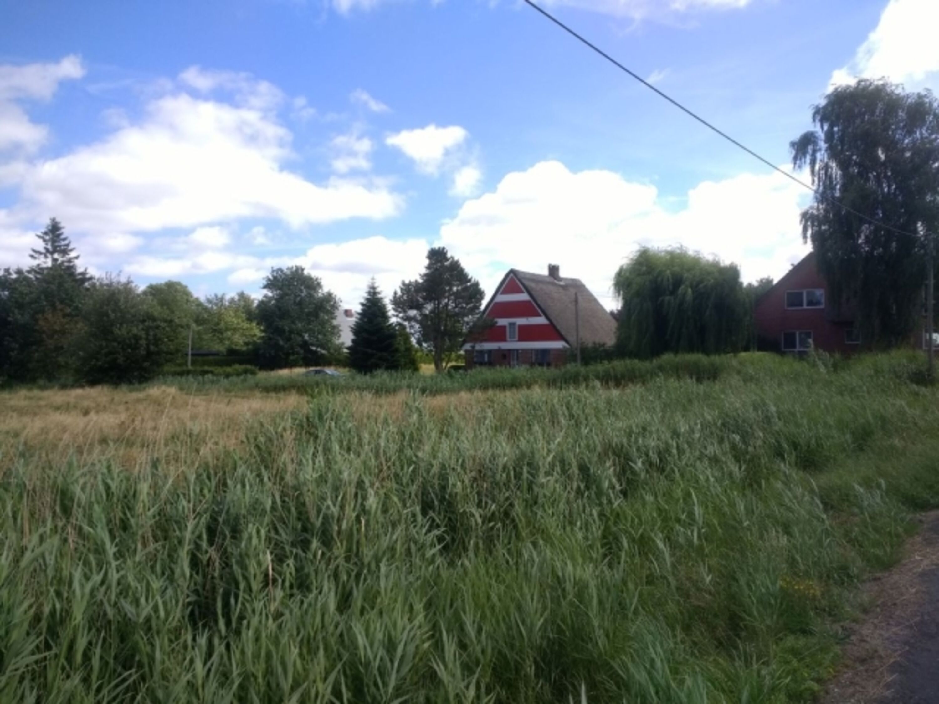 vor dem Gebäude trennt ein weitläufiges Feld Sie von der Hauptstraße