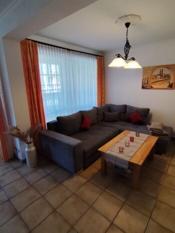 Gemütliches Wohnzimmer mit Sitzgruppe und Kaminofen