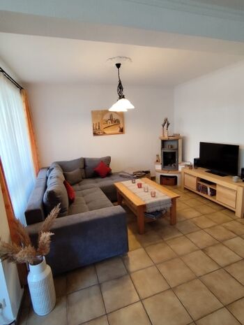 Gemütliches Wohnzimmer mit Sitzgruppe und Kaminofen