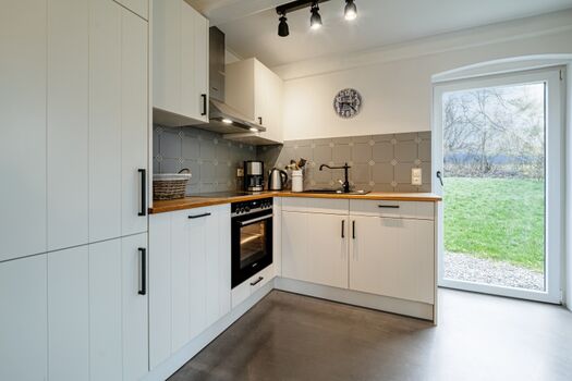 Wunderschöne Landhausküche mit Kamin und Zugang zum Garten