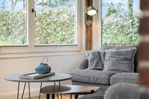 Heller Wintergarten als Wohnzimmer mit TV und Gartenblick