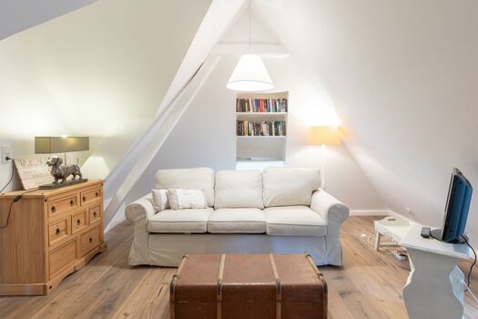 Witthuis - Kleines Schlafzimmer mit gemütlicher Sofaecke und TV