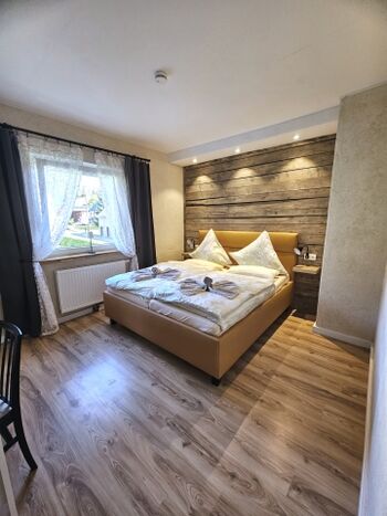 Schlafzimmer im EG mit Fernseher und Schreibtisch