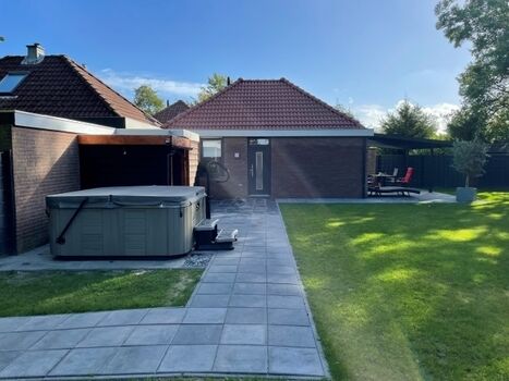 Blick auf das Ferienhaus mit seitlichem Blick zum Whirlpool 