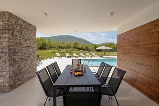 Es gibt einen überdachten Essbereich im Freien für 8 Personen mit einem Gasgrill