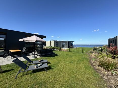 mit gemütlicher Lounge, Gartenmöbeln und Sonnenschirm