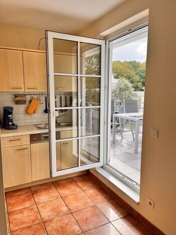 Helle Einbauküche mit Zugang zur Dachterrasse