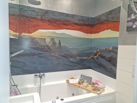 „Wellness-Oase 2: Tauchen Sie ab in der luxuriösen Whirlpool-Badewanne mit stimmungsvollem Berg-Panorama.“