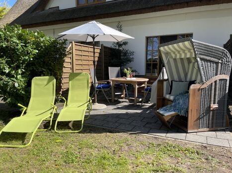Terrasse mit Strandkorb, Gartenmöbeln und Sonnenliegen