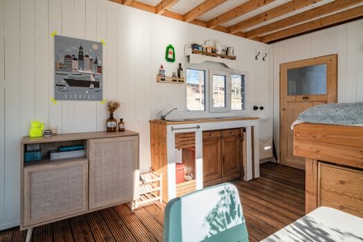 Der Hauptraum mit Küchenzeile, Bett und Esstisch