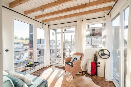 Der verglaste Wohnbereich mit Schlafcouch (1,20 m breit) vorne; von hier aus geht es auf die Terrasse