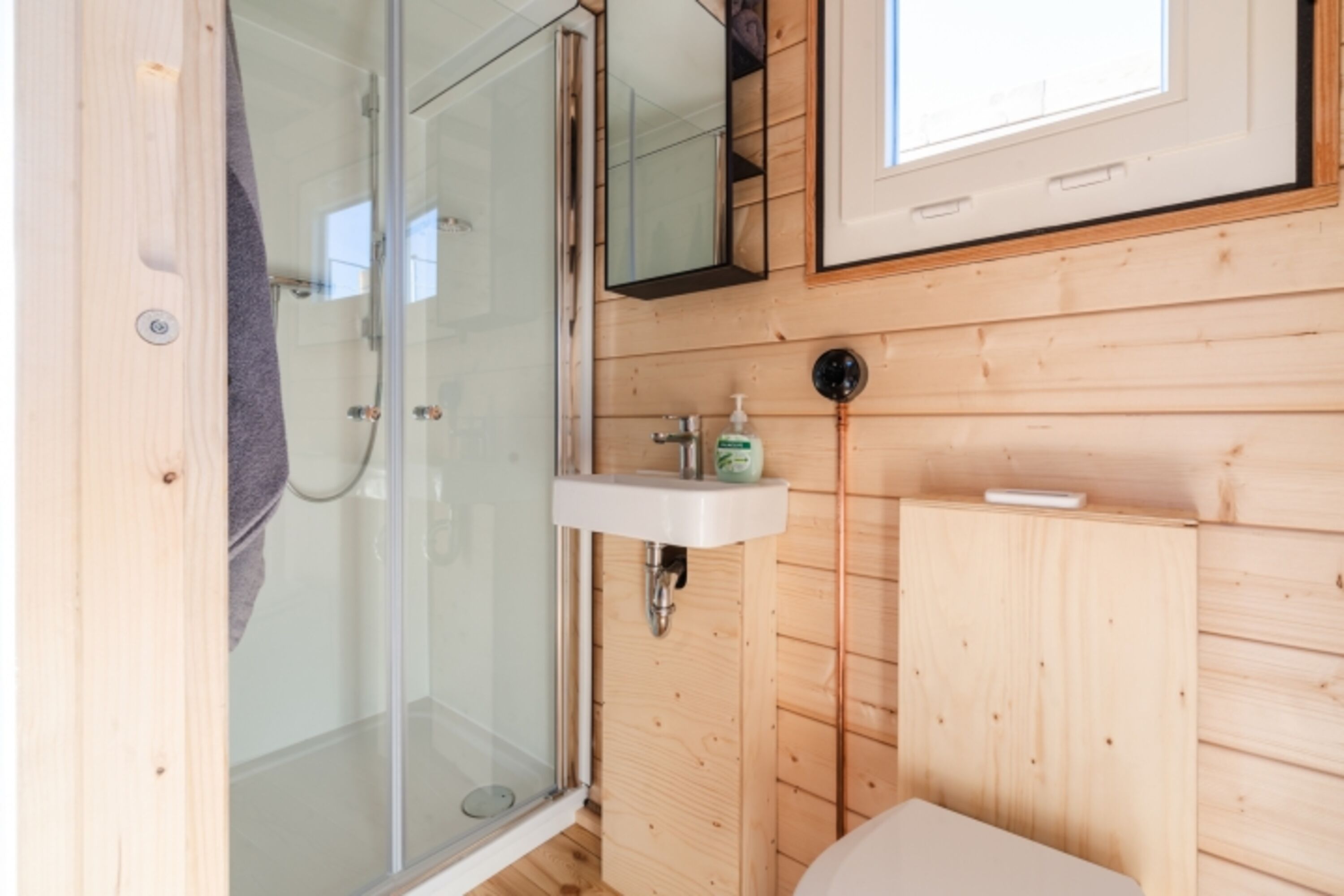 Bad mit normaler Dusche, kleinem Waschbecken und Wasserschiffstoilette