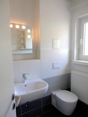 Modernes Bad mit ebenerdiger Dusche und Fenster