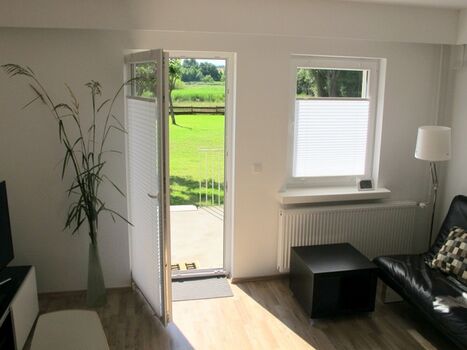 vom Wohnzimmer geht es mit ein paar Schritten über die Terrasse auf die große Wiese