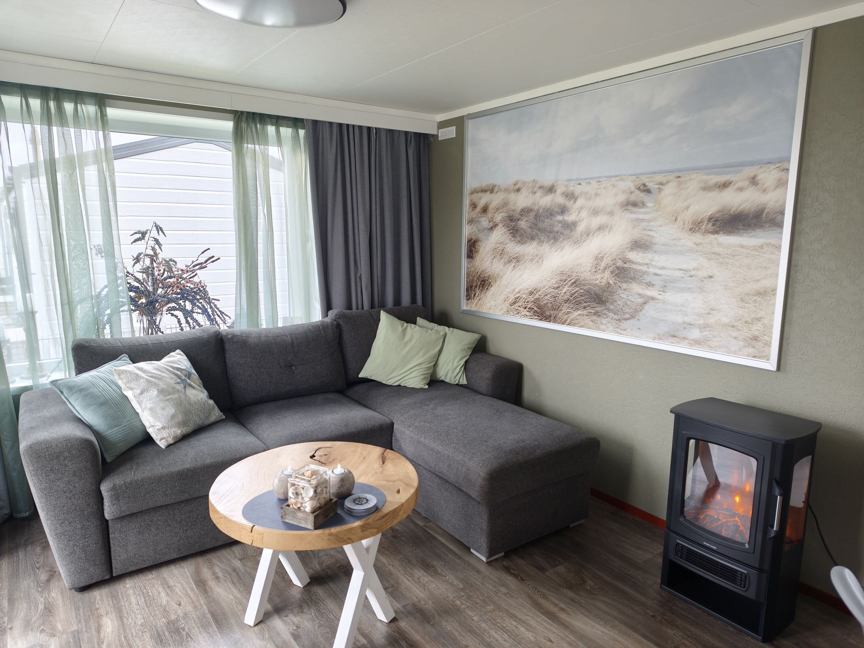 Schlafcouch im Wohnzimmer und ein elektrischer Kamin für gemütliche Abende.