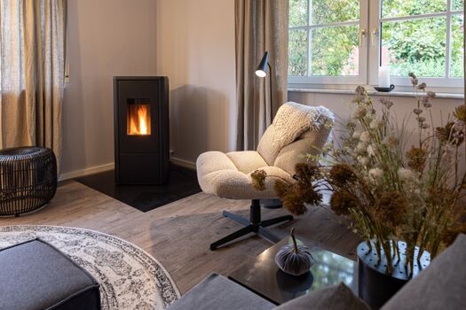 Gemütliches Wohnzimmer mit Klafs S1 Sauna und stimmungsvollem Flammenspiel