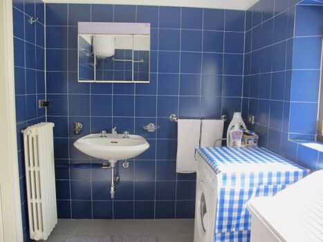 Badezimmer mit Waschmaschine im Erdgeschoss. 