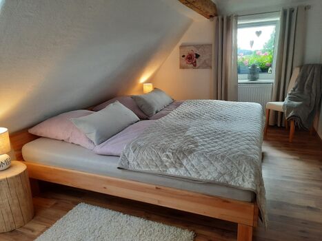 Schlafzimmer mit Doppelbett und TV