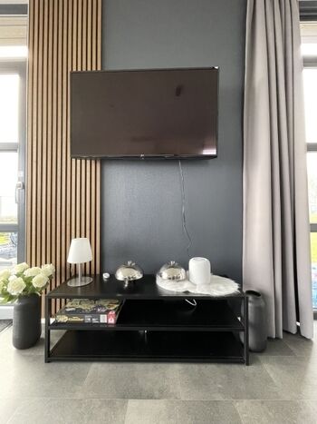 TV mit Ambiente-Beleuchtung im Wandpaneel