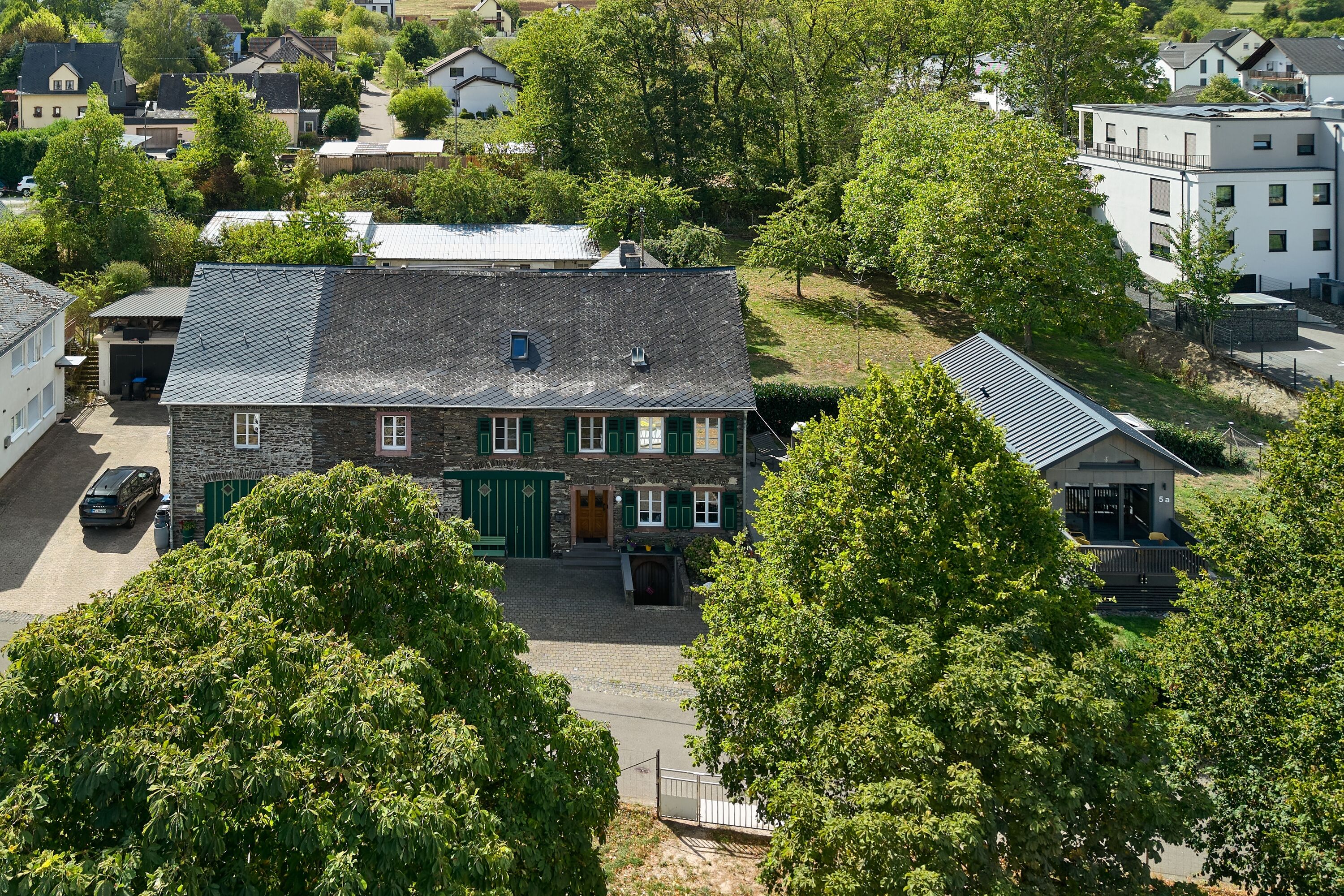 Luftaufnahme Bruchsteinhaus, rechts das Tiny House